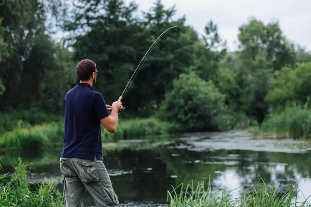 un homme pêche sur un lac a la mouche