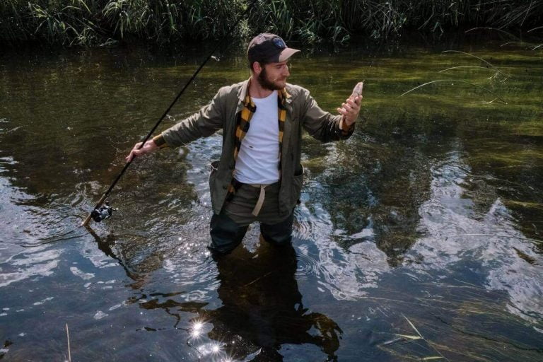 un homme qui pêche un bar avec sa canne pêche et le meilleur moulinet pour le bar